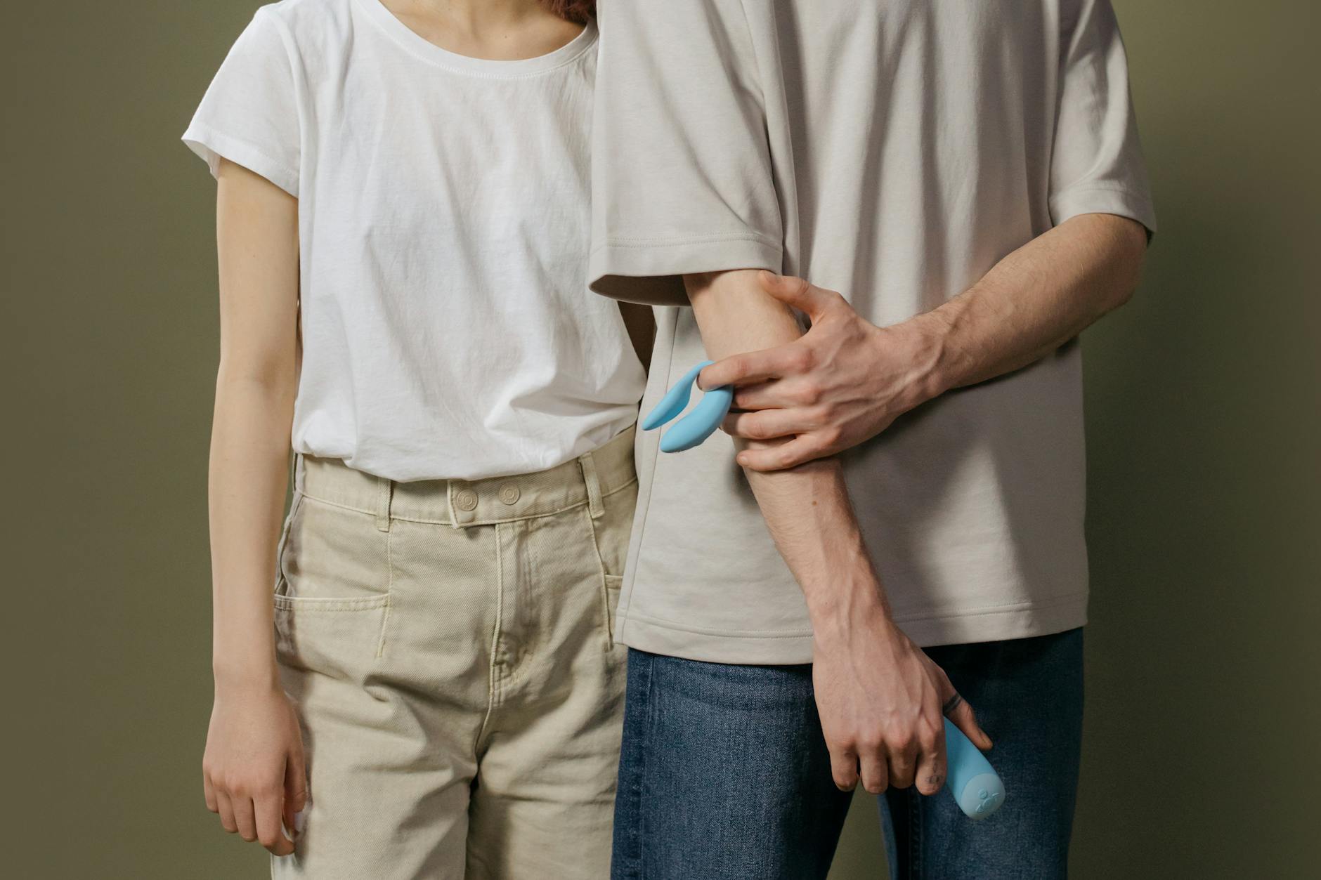 Couple moderne tenant un vibromasseur coloré, représentant l'intimité contemporaine et la contraception