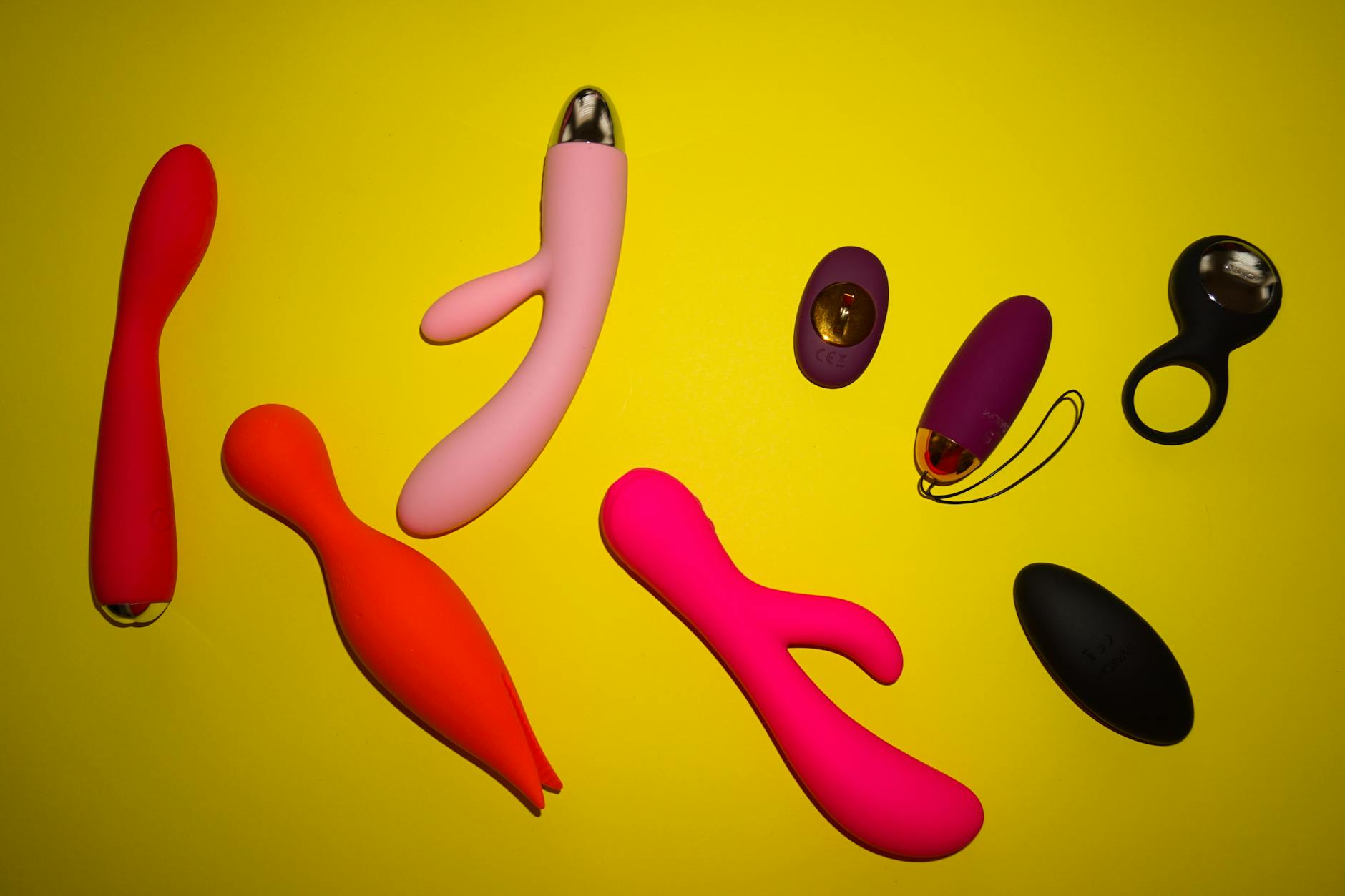 Arrangement coloré de jouets pour adultes sur une surface jaune vif